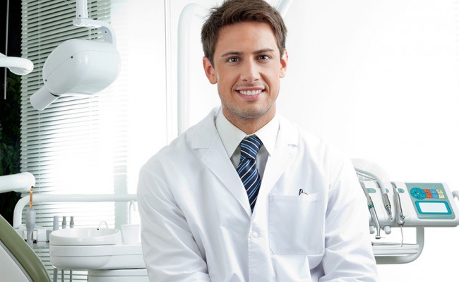 Happy Male Dentist In Clinic