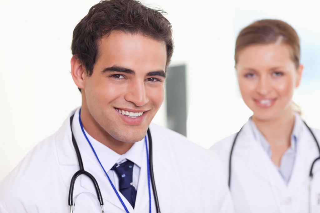 Smiling assistant doctors standing next to each other